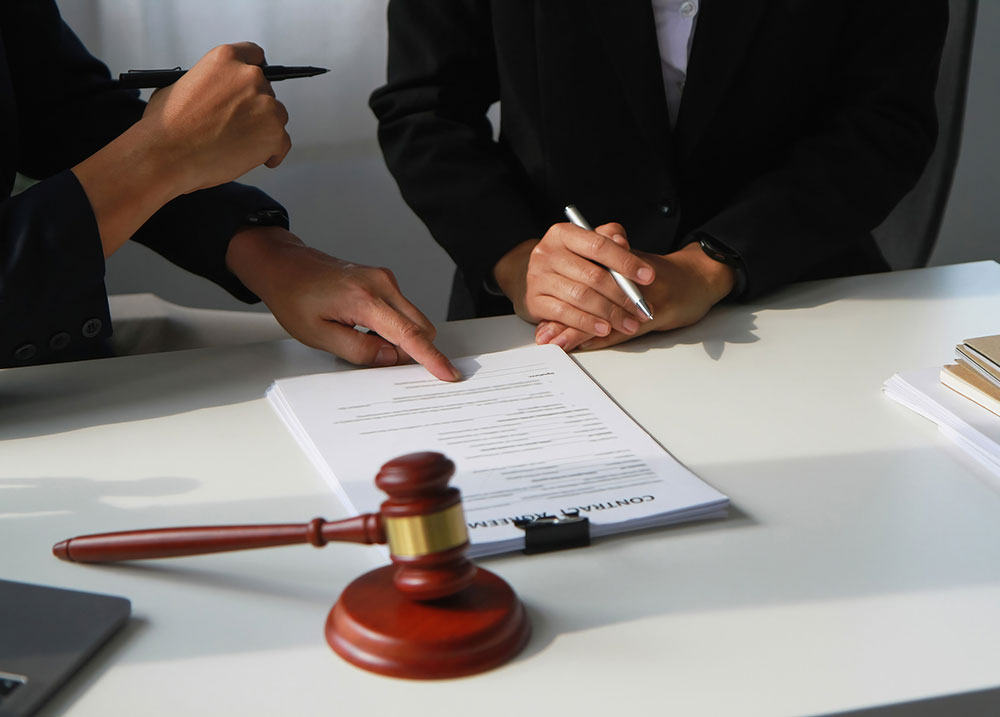 Personal injury lawyer preparing a client for a deposition by reviewing documents together in a Massachusetts law office.