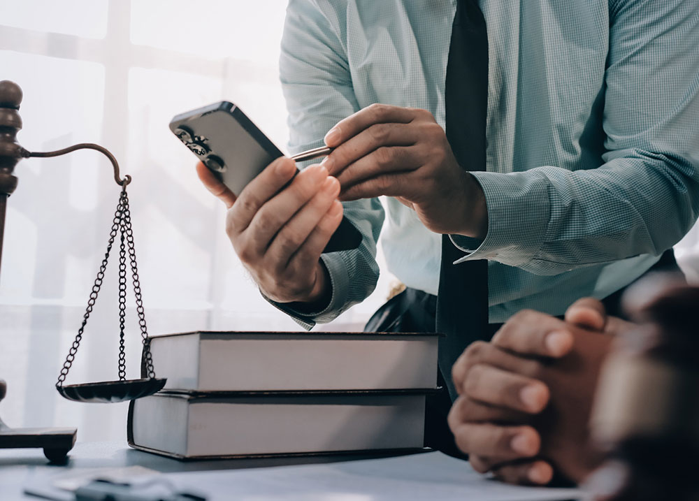 Lawyer reviewing social media posts on a smartphone, representing how insurers use online activity as evidence in Massachusetts injury claims.