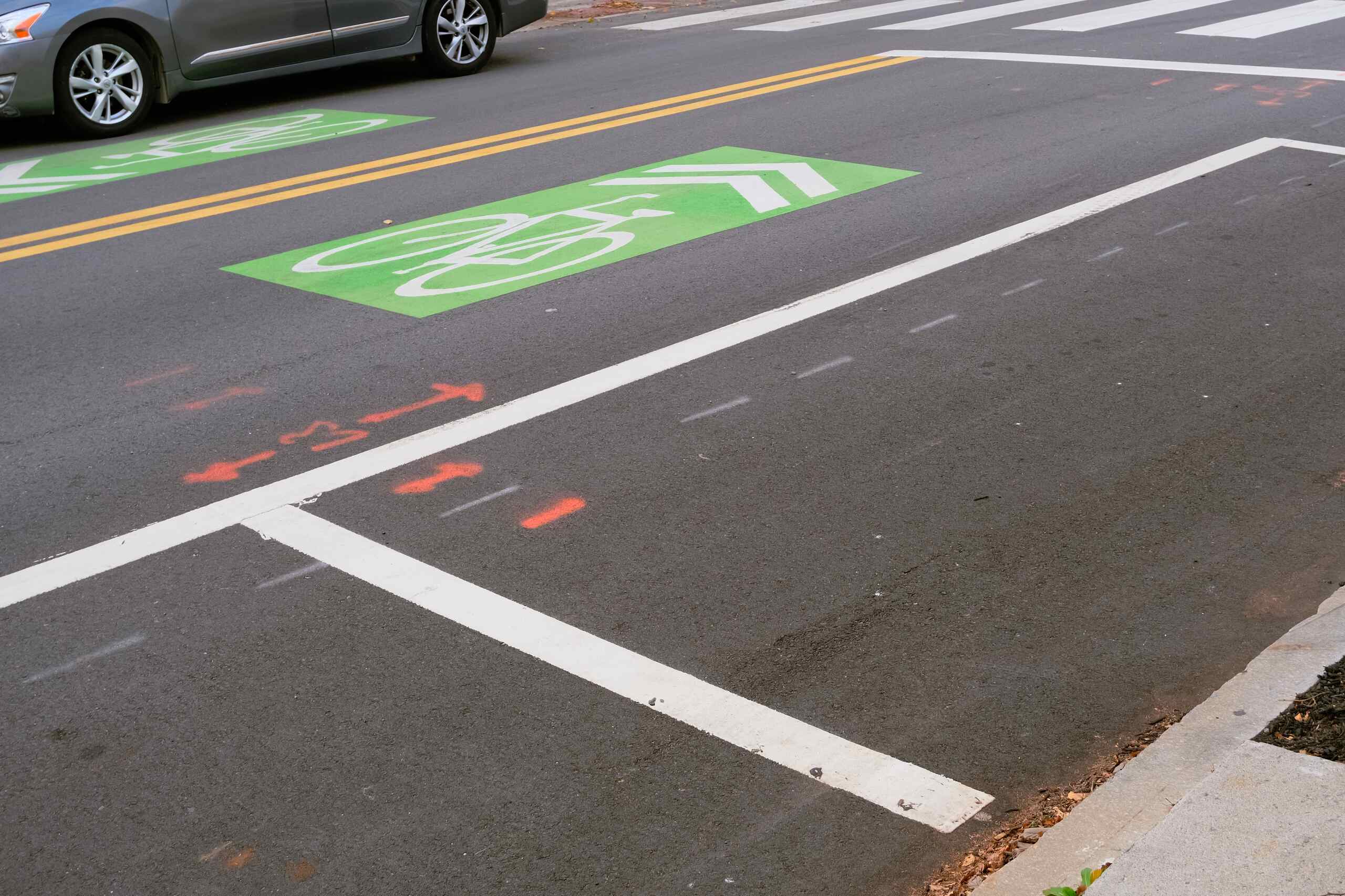 A marked crosswalk and green-painted bike lane in Springfield, illustrating where drivers must yield under Massachusetts pedestrian laws.