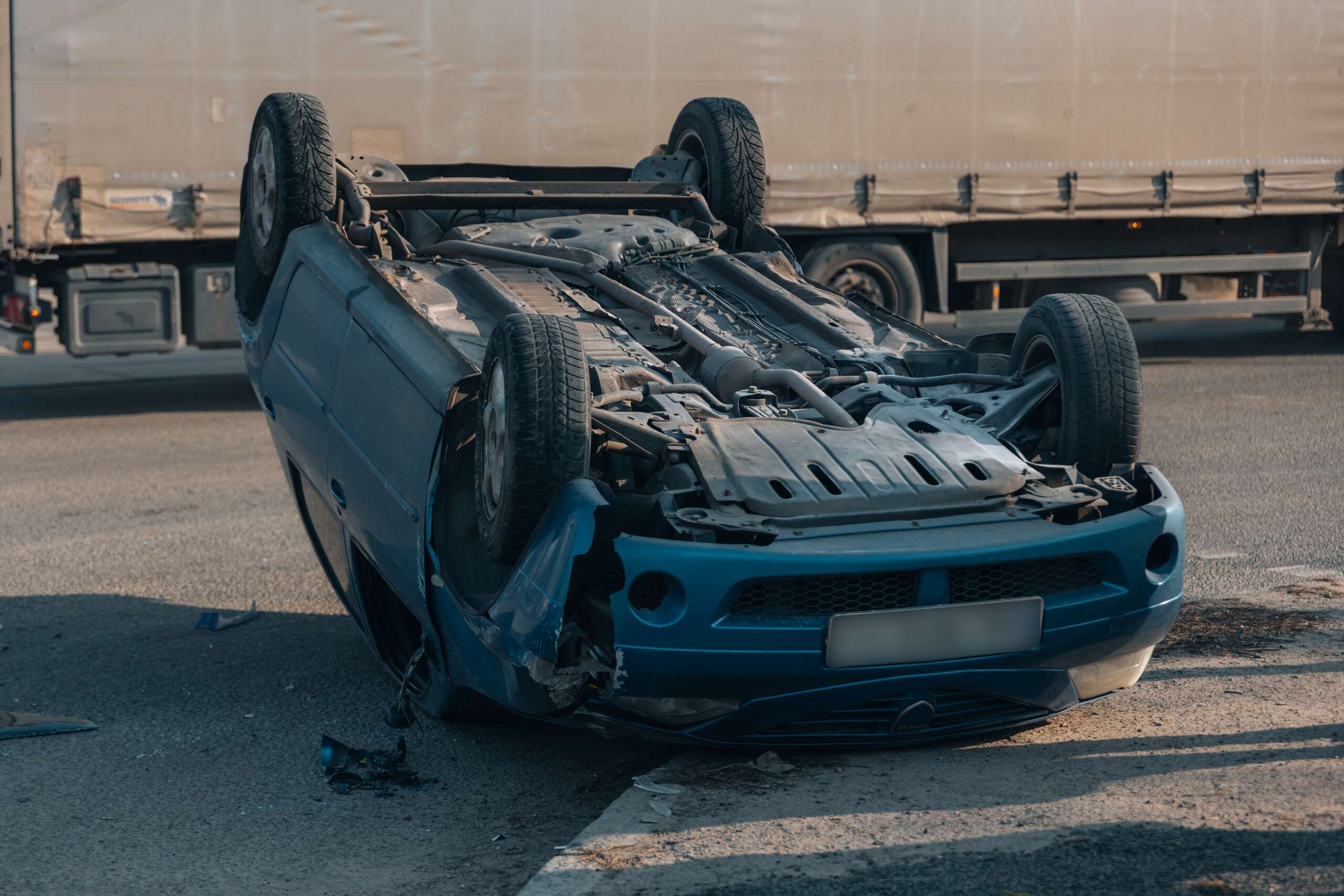 Overturned car lying on its roof after a highway accident, related to Massachusetts' comparative negligence rule explained.